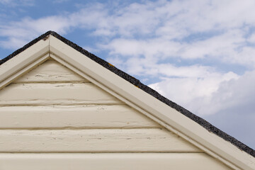 Cream painted wooden shed or hut with copy space and blue sky above