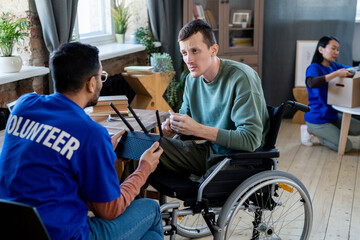 Two young men talking while one of them sitting in a wheelchair