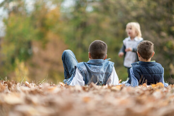 children play outside in fallen leaves