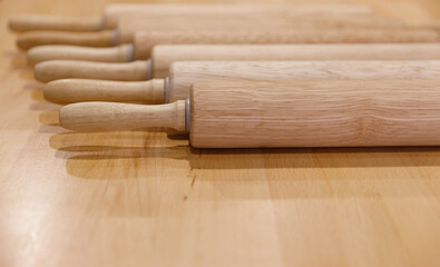 wooden rolling rollers to roll out the dough lie in a row on a wooden table. selective focus.High quality photo