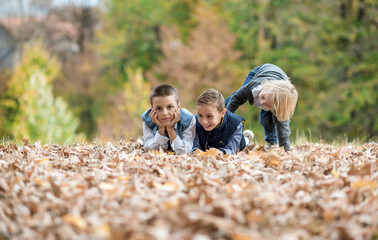 children play outside in fallen leaves