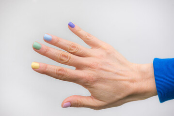 Female hand with rainbow painted nails manicure