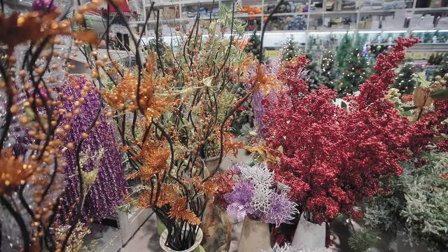Artificial flowers for a holiday for every taste and budget. On the background, the colorful lights of Christmas trees and the new year are flashing and glowing.