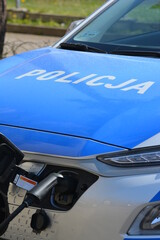 Elektryczny samochód policji polskiej na parkingu.  © FotoDax