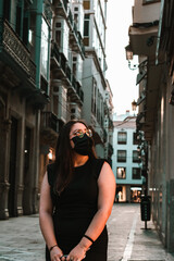 Chica bonita iluminada por un cartel publicitario en una calle desierta y poco iluminada