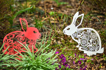 Two decorative hares are sitting in the garden