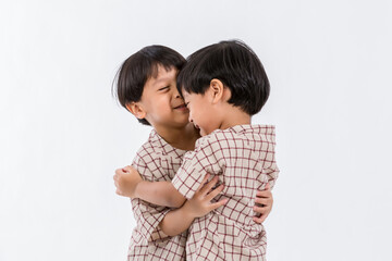 Studio portrait of twins children on a white background. Funny couple of identical brothers  on a white background. Twins baby boy.