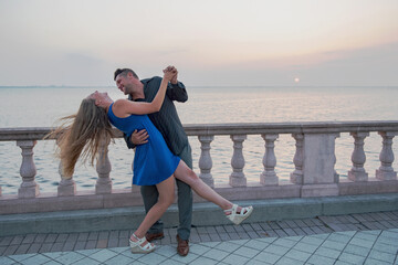 Romantic Couple Smiling and Dancing at Sunset Along Bayfront