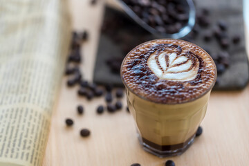 Coffee Latte Art. The coffee arts. Hot coffee in a white cup on wooden table. Hot chocolate Nutella latte art on wood table.