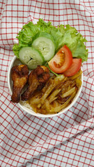 Healthy fresh rice bowl with tomato green cuisine and fried chicken thigh on red squared cloth