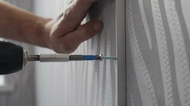 Furniture assembly. House improving and repairing. handyman at work. Locksmith screwing. Tighten screw with a screw driver. Slow motion. Drilling nail into wall. Construction worker. Full hd