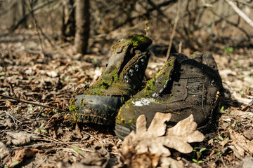 Boots abandoned in the forest, overgrown with moss