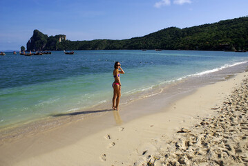 Fototapeta na wymiar Young fashionable woman resting on the beach of paradise island.