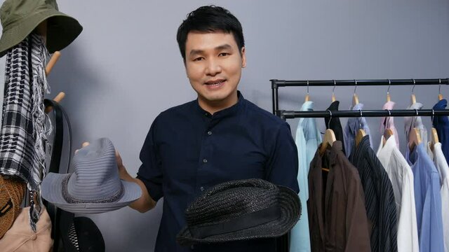 Young man selling hat and clothes online by smartphone live streaming, business online e-commerce at home