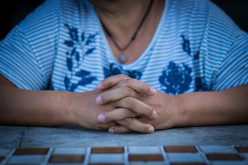Obraz premium Sao Paulo, SP, Brazil - February 15 2020: mother hands with fingers crossed on the table