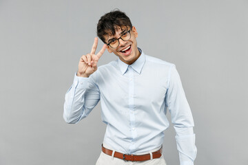 Young smiling successful employee business latin man corporate lawyer in classic white shirt glasses show victory v-sign gesture isolated on grey background studio portrait Career achievement concept.