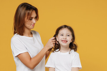 Happy woman in basic white t-shirt have fun with cute child baby girl 5-6 years old. Mommy little kid daughter isolated on yellow orange color background studio. Mother's Day love family concept