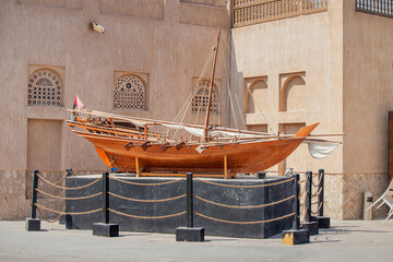 Ancient wooden Arba Dhow rowing boat on a pedestal near the museum in Dubai Creek