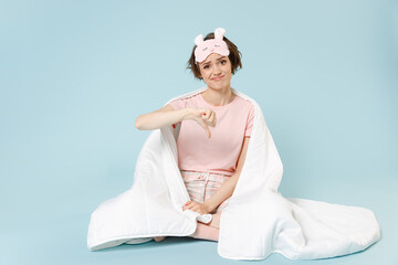 Young sad displeased woman wear pajamas jam sleep eye mask rest at home sit wrap covered under...