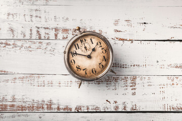 Old metal clock overhead arrangement on old rustic white wooden table with copy space studio shot