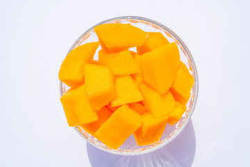 Cantaloupe fresh melon cubes in glass bowl on beige background. Organic vegetarian healthy food. Diet dessert fruit.