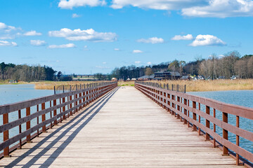 Fototapeta na wymiar wooden bridge over the lake, beautiful blue sky with clouds