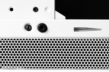 Horizontal ventilation grille. Round holes. Metal construction. Dark background. Front view close-up. Black and white tones.