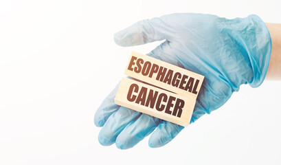 Doctor's hand in blue glove shows the wooden cubes with word esophageal cancer. Medical concept.