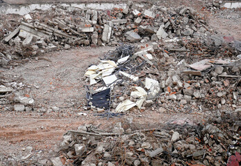 Materials and debris on the ground during the demolition of a reinforced concrete and brick industrial building