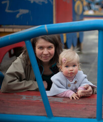 Fototapeta na wymiar Mom with a little daughter on the playground