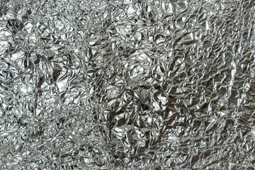 Crumpled and shiny sheet of aluminum foil texture for background.