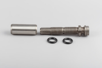 The repair kit for the spring from the pin bushing and gaskets lies on a gray background. Bushing and finger for truck repair. automotive components for heavy vehicles