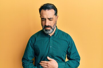 Fototapeta premium Middle age man with beard and grey hair wearing business clothes with hand on stomach because indigestion, painful illness feeling unwell. ache concept.