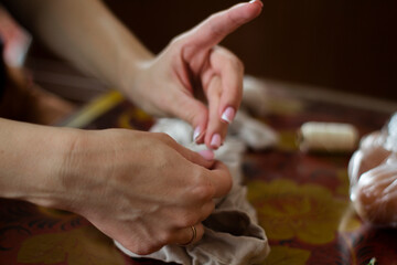 female hands hold an egg in nylon for painting for Easter, tights in hand 