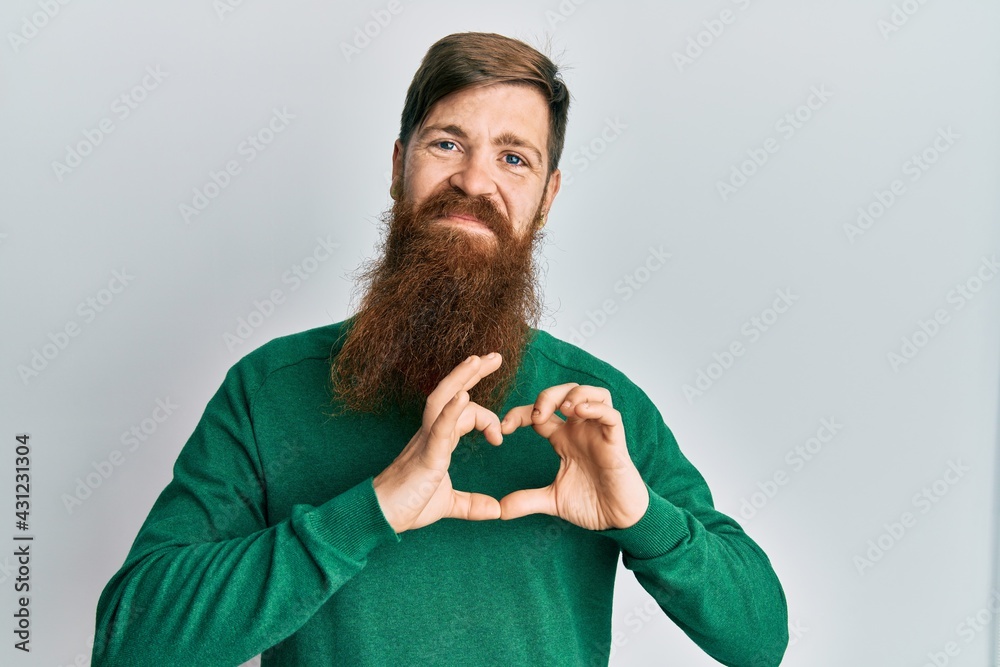 Sticker Redhead man with long beard wearing casual clothes smiling in love doing heart symbol shape with hands. romantic concept.