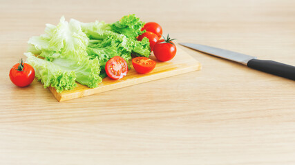 Fresh ripe ready-to-eat vegetables on wooden cutting board. Angle shot, natural light, soft...