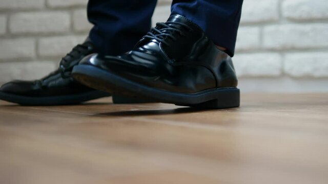 The owner knocks on the ground with his foot, men's shoes are classic black, men's shoes are modern. Knock the floor with your foot. Language of the body