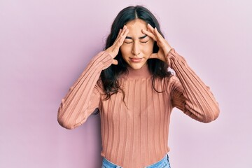 Hispanic teenager girl with dental braces wearing casual clothes suffering from headache desperate and stressed because pain and migraine. hands on head.