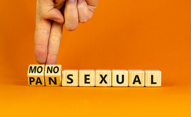 Monosexual or pansexual symbol. Doctor turns wooden cubes and changes the word 'monosexual' to 'pansexual'. Beautiful orange background, copy space. Social, monosexual or pansexual concept.