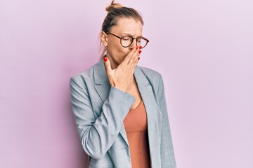 Beautiful caucasian woman wearing business jacket and glasses bored yawning tired covering mouth with hand. restless and sleepiness.