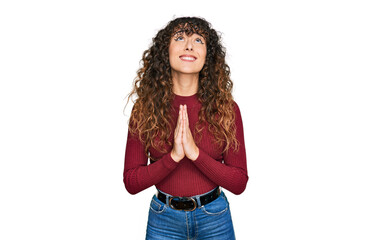 Young hispanic girl wearing casual clothes begging and praying with hands together with hope expression on face very emotional and worried. begging.