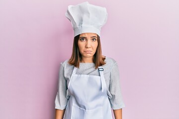 Young beautiful woman wearing professional cook uniform and hat depressed and worry for distress, crying angry and afraid. sad expression.