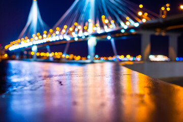 Suspension bridge over the river. Highlighting the bridge. Panorama of the night city. Close up...
