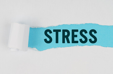 In the middle of a white sheet of paper, a tear is made under which, on a blue background, the inscription - STRESS