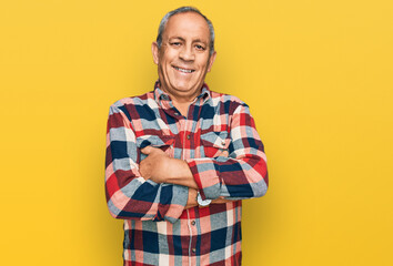 Senior hispanic man wearing casual clothes happy face smiling with crossed arms looking at the...