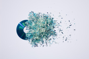 Datenvernichtung von CD oder DVD in Vielzahl funkelnder Teilchen auf weißer Platte