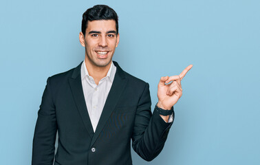 Handsome hispanic man wearing business clothes with a big smile on face, pointing with hand finger...