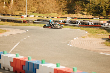  six year old boy drives go-kart. Small child drives kart on a racetrack. Boy with helmet does a race on the go-kart track. Copy space for text