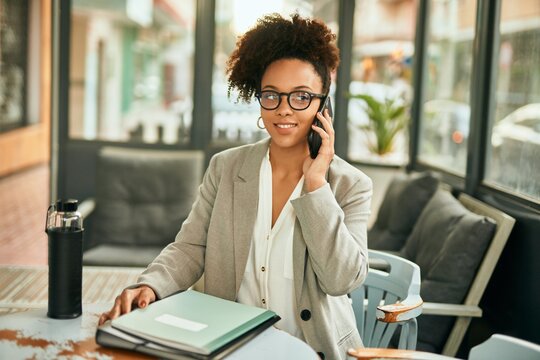 Young african american businesswoman smiling happy talking on the smartphone sitting at coffee shop.