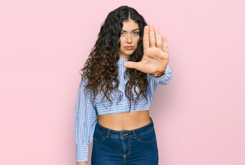 Young hispanic girl wearing casual clothes doing stop sing with palm of the hand. warning...